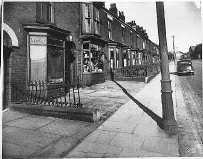 [terraced houses, car and cobbled road]