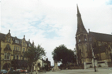 [church with spire and buildings]