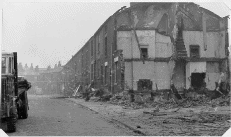 [road with partly demolished houses]